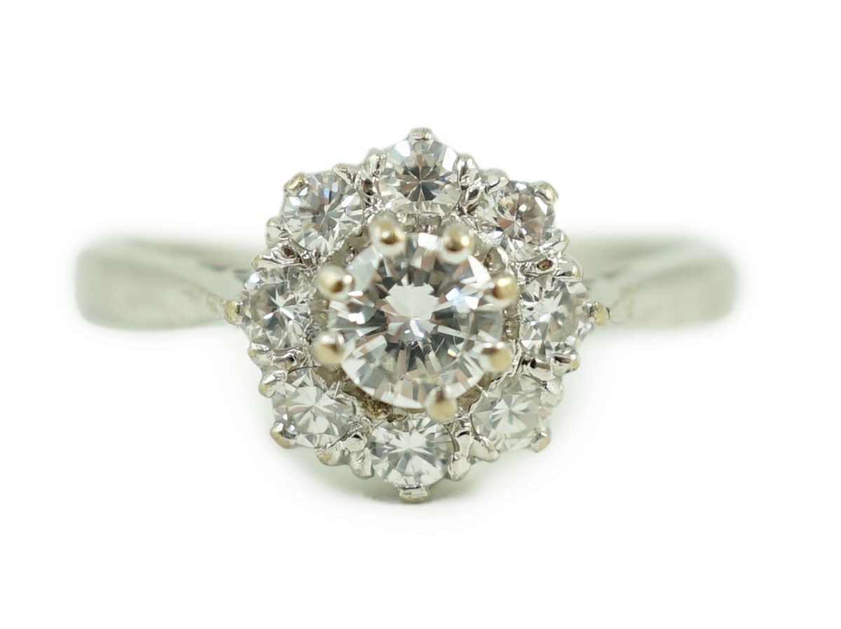 A modern 18ct white gold and nine stone diamond set flower head cluster ring